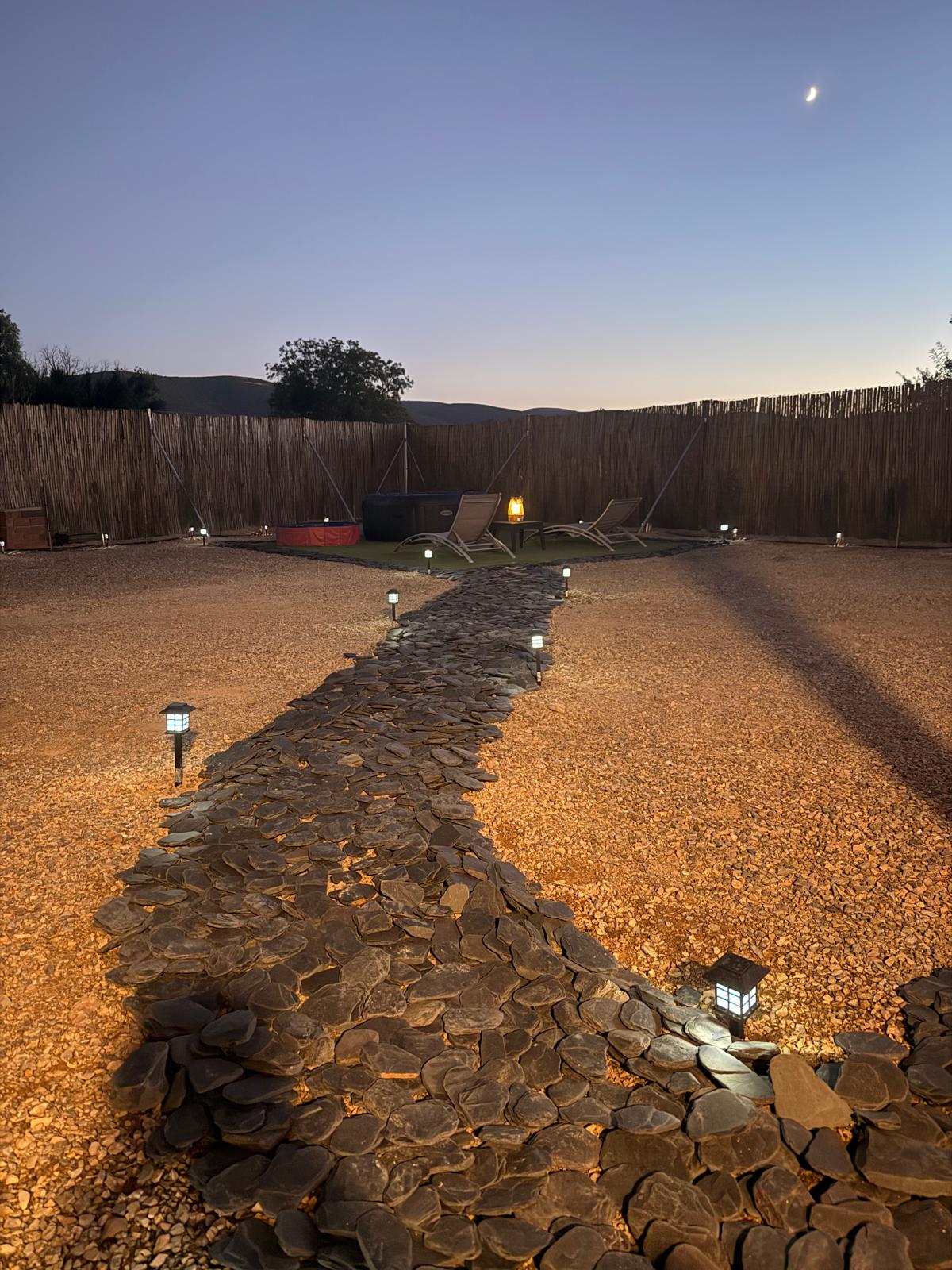 Camino de piedra iluminado en la finca Los Almendros de noche